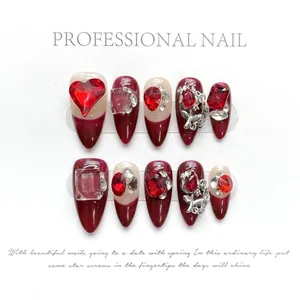Detailed view of handmade press-on nails with red heart rhinestones and silver roses