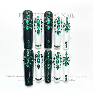 Detail of emerald green rhinestones and sparkling gems on long trapezoid press-on nails