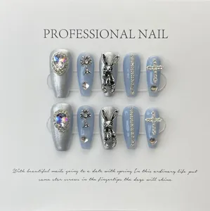 Vista macro di unghie lunghe Coffin con glitter argento, croci e ciondoli a coniglio 3D