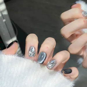 Dettaglio di unghie finte fatte a mano effetto cat eye con glitter argento e strass chic