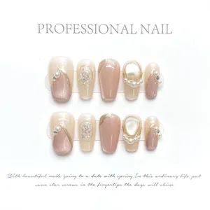 Detail of press-on nails featuring cat-eye effect with pearls and rhinestones