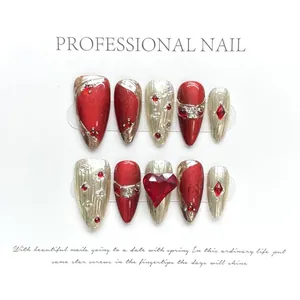 Detail of handmade red and silver press-on nails with 3D heart rhinestone decoration