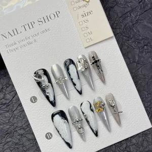 Unghie finte glitter argento con design marmorizzato, croce in metallo e pendenti