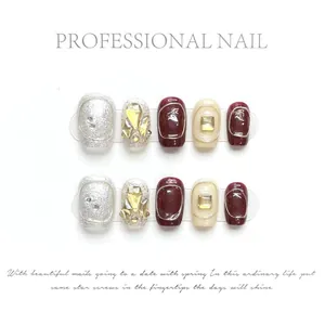 Detailed view of handmade press-on nails in burgundy and silver with luxury crystal gems