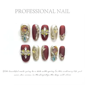 Detailed view of handmade wine red press-on nails with 3D rhinestones and pearl accents