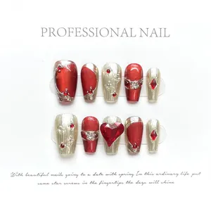 Detailed set of red and gold press-on nails with 3D gems, pearls and cat-eye effect
