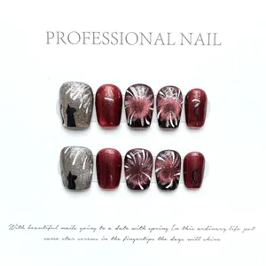Detail of red cat-eye handmade press-on nails with silver glitter and cat silhouette art