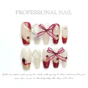 Detail of handmade press-on nails featuring vintage red, 3D bows, and gold leaf accents