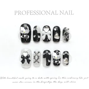 Detail of handmade press-on nails featuring 3D bows and silver metallic charms