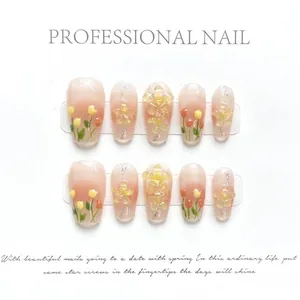 Detailed view of handmade press-on nails with pink gradient and tulip flower art