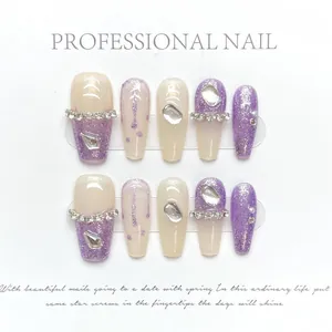 Detail view of purple glitter press-on nails with rhinestones and moon charms