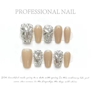 Vue macro de faux ongles faits main nude avec paillettes argentées et strass de luxe