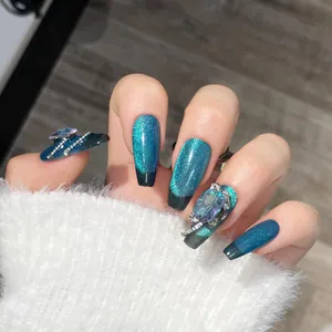 Detalle de uñas postizas largas tipo ataúd efecto ojo de gato azul con pedrería fina 3D