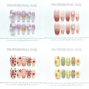 Detalle de cuatro uñas postizas hechas a mano con flores 3D y amuletos de corazón