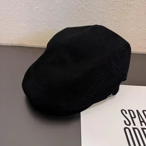 Détail de la texture côtelée verticale d'une casquette plate noire en velours côtelé