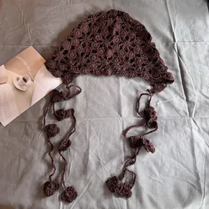 Détail d'un bandana au crochet marron foncé avec attaches à fleurs et texture en maille rétro
