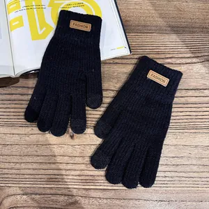 Detailed texture of black thermal knit gloves with a decorative fashion leather patch