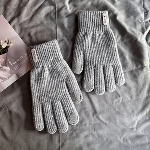 Gros plan de gants d'hiver en tricot gris avec étiquette Classic et bouts tactiles