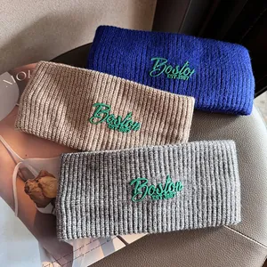 Three knitted winter headbands with Boston 1987 embroidery in blue, brown, and grey