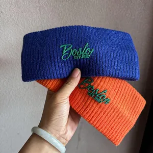 Detail of navy and orange knit headbands featuring green Boston EST.1987 embroidery