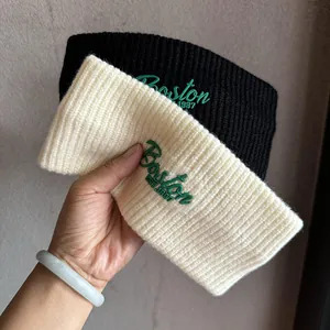 Detail of ribbed knit headbands in black and cream featuring Boston 1987 embroidery