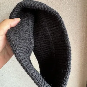 Detailed view of dark grey ribbed knit texture and thick winter beanie construction