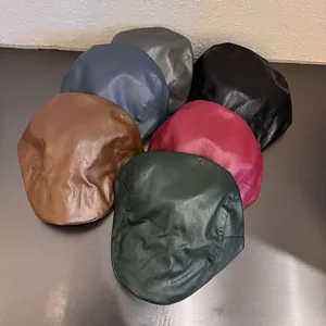 Detail of multiple PU leather berets in various colors with premium texture and stitching