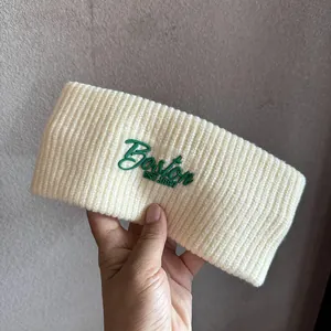 Macro detail of cream knit headband featuring green Boston EST 1987 embroidery