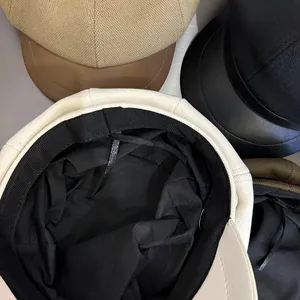 Close-up of newsboy caps with PU leather brims and internal adjustable drawstrings