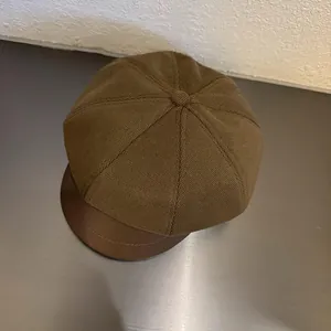 Close-up of brown newsboy cap with wool octagonal top and smooth leather brim