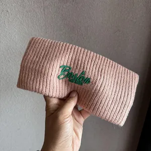 Close-up of pink knitted headband featuring green Boston EST. 1987 embroidery detail