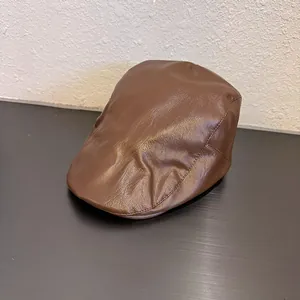 Detail shot of vintage dark brown PU leather beret showing fine texture and stitching