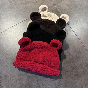 Detailed knit texture of four colorful winter beanie hats with cute bear ear designs