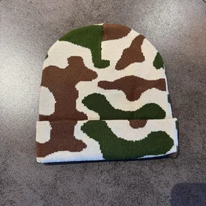 Detail of winter camouflage knitted beanie with woodland green and beige pattern