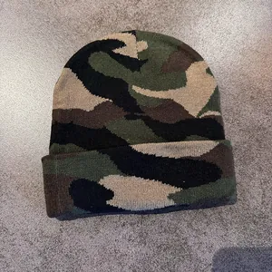 Detail shot of the woodland camouflage knit pattern and textured stitching on the beanie