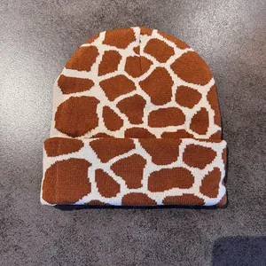 Detailed close-up of giraffe pattern knit beanie with textured wide-cuff design