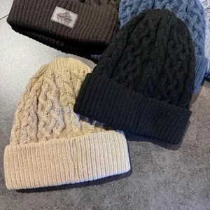 Detail van de kabelgebreide textuur en diverse kleuren dikke wintermutsen met fleece