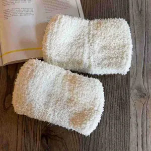 Chaussettes douces en peluche crème sur fond de bois sombre pour un confort hivernal