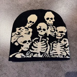 Close-up of black knitted beanie with white skull jacquard pattern for Halloween style