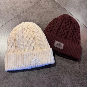 Dikke gebreide wintermutsen in beige en bordeaux met warme fleecevoering en logo