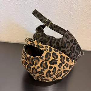 Detail of adjustable metal buckle and vintage leopard print canvas on two baseball caps