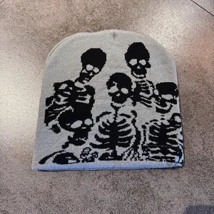 Macro detail of the grey knitted beanie featuring black skeleton graphic patterns