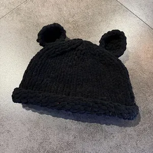 Close-up of black handmade knit hat featuring cute 3D bear ears and thick wool texture