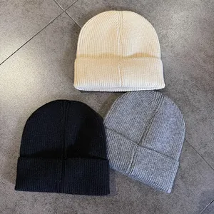 Dettaglio della maglia a coste dei berretti beige nero e grigio con risvolto alto