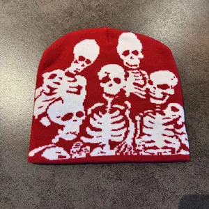 Close-up of red knitted beanie featuring white skull patterns for Halloween party style