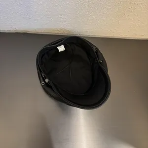 Detail view of the black PU leather beret interior with lining and adjustable drawstring