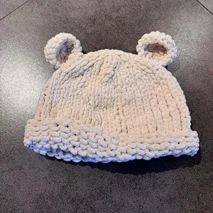 Close-up of thick beige chenille knit hat with cute bear ears and soft texture detail