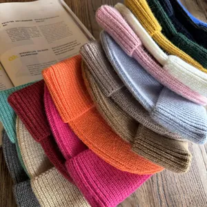 Pile di berretti in maglia a coste colorati con varie tonalità e texture morbida