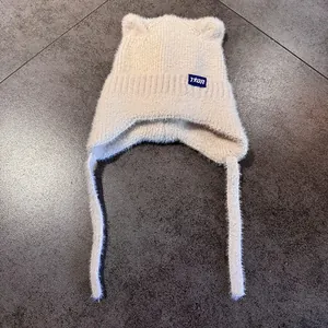 Primer plano del gorro de punto crema con orejas de gato y suave textura de felpa