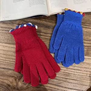 Cozy knit fingerless gloves in red and blue colors on a vintage wooden tabletop